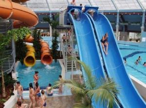 a pool on a cruise ship with people on a water slide at Gold Downtown Apartman in Debrecen