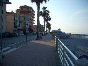 chodnik obok plaży z palmami w obiekcie Appartamento al mare di Ventimiglia w mieście Ventimiglia
