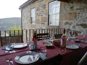 Mesao Provesende في Provesende: طاولة عليها صحون و زجاجات نبيذ و كاسات