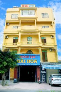 żółty budynek z znakiem przed nim w obiekcie Hai Hoa Hotel w mieście Cửa Lô