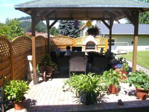 a patio with a gazebo and tables and potted plants at Ferienwohnung Familie Arlt in Königstein an der Elbe +2 photos