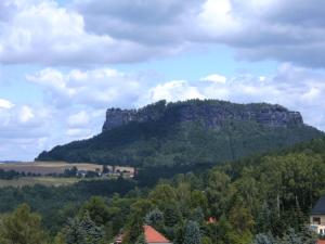 a mountain in the distance with trees and houses at Ferienwohnung Familie Arlt in Königstein an der Elbe