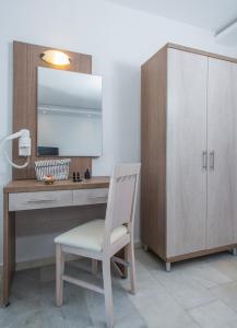 a desk with a white chair next to a wooden cabinet at Naxos Holidays in Naxos Chora