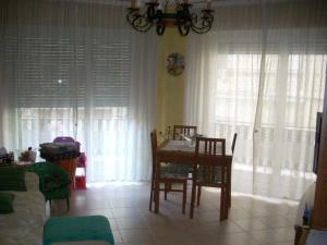 jadalnia ze stołem, krzesłami i oknami w obiekcie Appartamento al mare di Ventimiglia w mieście Ventimiglia