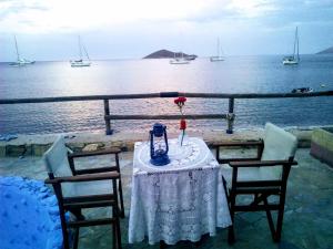 a table with two chairs and a vase with a flower on it at Paradisso Studios in Vromolithos