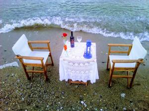 einen Tisch und zwei Stühle am Strand in der Unterkunft Paradisso Studios in Vromolithos