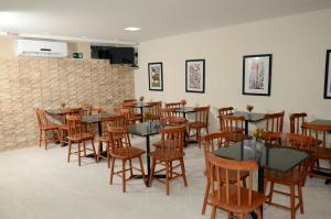 a dining room with tables and chairs and a brick wall at Asa Branca Hotel in Araripina