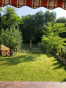 a view of a yard with trees and a lake at Vml Premium Apartman in Mosonmagyaróvár