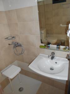 a bathroom with a sink and a toilet and a mirror at Element Hotel in Elafonisos