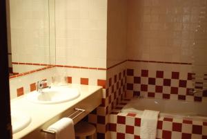 ボカイレントにあるL'Agora Hotelの洗面台と浴槽のあるバスルーム +39枚の写真