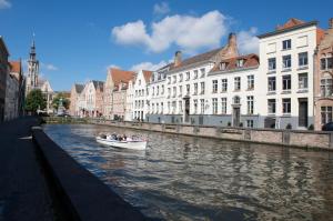 a small boat is docked in the middle of a river at Martin's Relais in Bruges