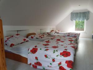 a bedroom with two beds with red flowers on them at Ranczo u Nikodema in Silice