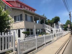 a white picket fence in front of a house at Mallard Apartments in Ocean City