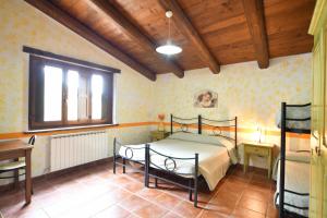 a bedroom with a bed and a table and a window at Agriturismo Valle Tezze in Cascia