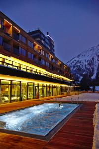 カルス・アム・グロースグロックナーにあるGradonna Mountain Resort Chalets & Hotelの雪山の夜間スイミングプール付きの建物