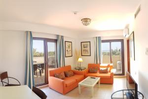 イスラ・カネラにあるMar Canela Apartmentsのリビングルーム(オレンジ色のソファ、テーブル付)