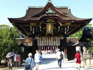 a group of people walking past a large building at ゲストハウスOneWorld Toji東寺 in Kyoto