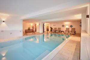 une grande piscine d'eau bleue dans un hôtel dans l'établissement Alpenhotel Schönwald Superior, à Valles