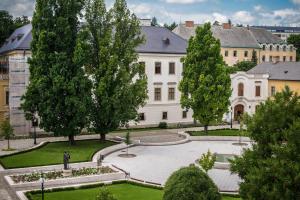 a large white building with trees and a courtyard at Suzy Apartman in Eger