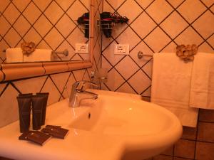 ein Badezimmer mit einem weißen Waschbecken mit Schokoladenmuster in der Unterkunft Tropea Casa Scirocco in Tropea