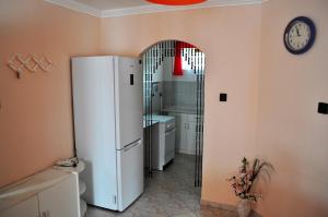 ザラカロシュにあるGitta Apartmanházのキッチン(白い冷蔵庫、時計付)