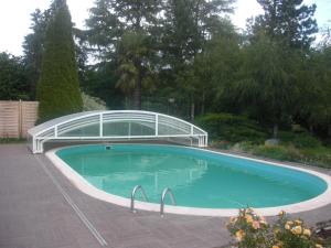 a swimming pool with a glass bridge over it at Le Clos Sainte Lea in Mouilleron-le-Captif