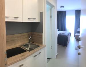 a kitchen with a sink and a bed in a room at Apartments Vila 4m in Ražanac +50 photos