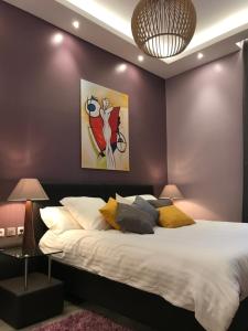 カンヌにあるNUMA BLANC 300 M PALAIS DES FESTIVALSの紫の壁のベッドルーム1室(大型ベッド1台付)