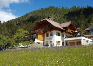 a house on a hill with a field of flowers at Haus Christina in Weissensee