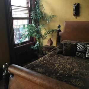 ein Schlafzimmer mit einem Bett und eine Pflanze neben einem Fenster in der Unterkunft Main Street Bed & Breakfast in Hannibal