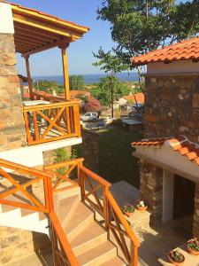 Eine Holztreppe führt zu einem Haus mit einem Steinkamin. in der Unterkunft Villa Makri in Mákri