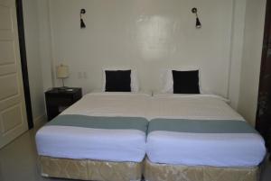 Gitagun的住宿－Lagoon beach resort，一间卧室配有一张大床和两个枕头