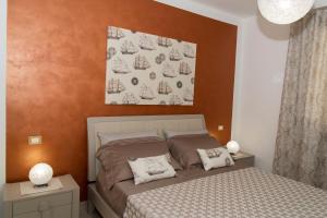 a bedroom with a bed and a painting on the wall at Casa Vacanze Fontana in San Vito lo Capo