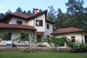 uma casa branca com um telhado castanho em Saulesdarzs em Ragaciems