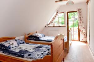 Un dormitorio con dos camas y una ventana. en Wilcza Gajowka, en Sosnówka