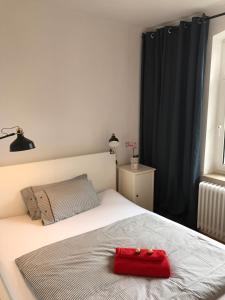 ein Schlafzimmer mit einem Bett mit einer roten Tasche darauf in der Unterkunft Nord Apartment in Kiel