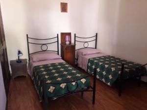 Habitación con 2 camas y mesa con reloj. en Nonna Bruna en Rieti