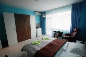 1 dormitorio con 1 cama con toallas verdes en Zoya Guest House, en Ravda