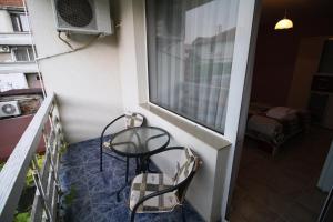 a balcony with a table and chairs and a window at Zoya Guest House in Ravda