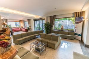 a large living room with couches and tables and windows at Comfort Hotel Gardenia Sorrento Coast in Sorrento