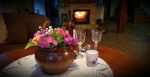 uma mesa com um vaso de flores e copos de vinho em Wilcza Gajowka em Sosnówka