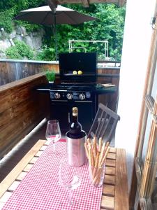 a picnic table with a grill and wine glasses at CHALET BELLE KITZ by Belle Stay in Kitzbühel