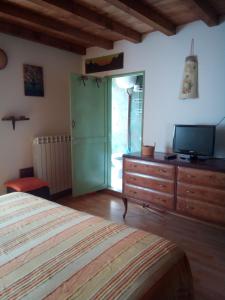 Schlafzimmer mit einem Bett und einer Kommode mit einem TV in der Unterkunft Calì B&B in Alatri