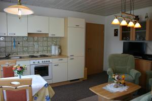a kitchen with white cabinets and a table in a room at Haus Elisabeth in Carolinensiel