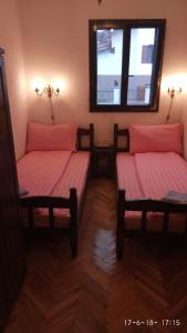 two twin beds in a room with a window at Apartments Vila Marija in Žabljak +4 photos