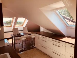 an attic kitchen with a table and a window at Panorama Apartament Sopot in Sopot