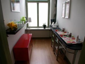 cocina con encimera roja y ventana en B&B Het Venloos Plekje, en Venlo