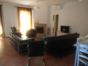 sala de estar con muebles negros y chimenea en Vivienda Rural, en Olivares