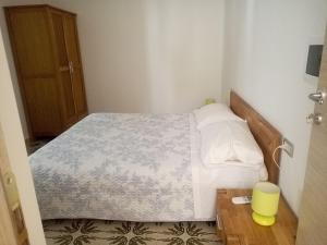 een kleine slaapkamer met een bed en een houten tafel bij I tre scalini in Stintino