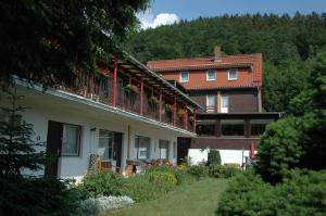 uma casa grande com uma varanda numa colina em Wiedaer Hütte em Wieda